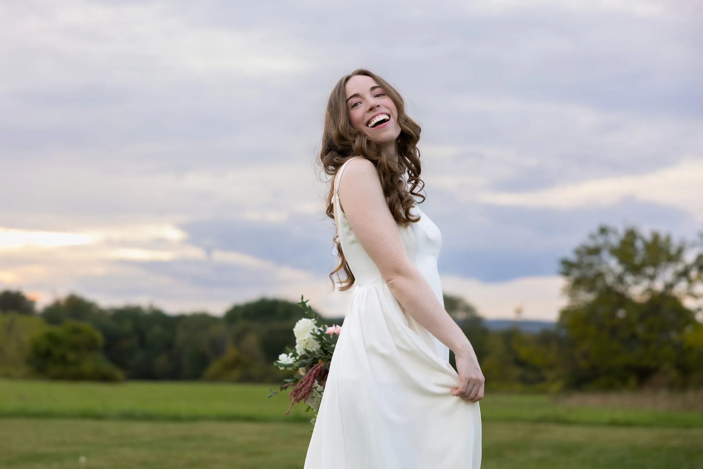 Bride laughing in the middle of the field
