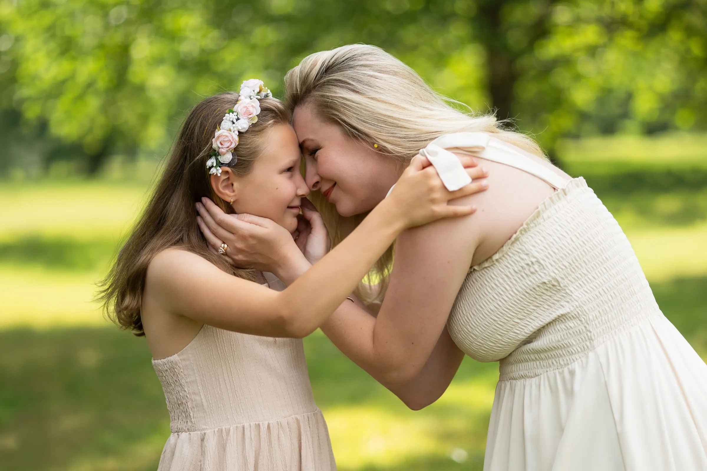 Mother cradling her daughter’s face, their foreheads touching
