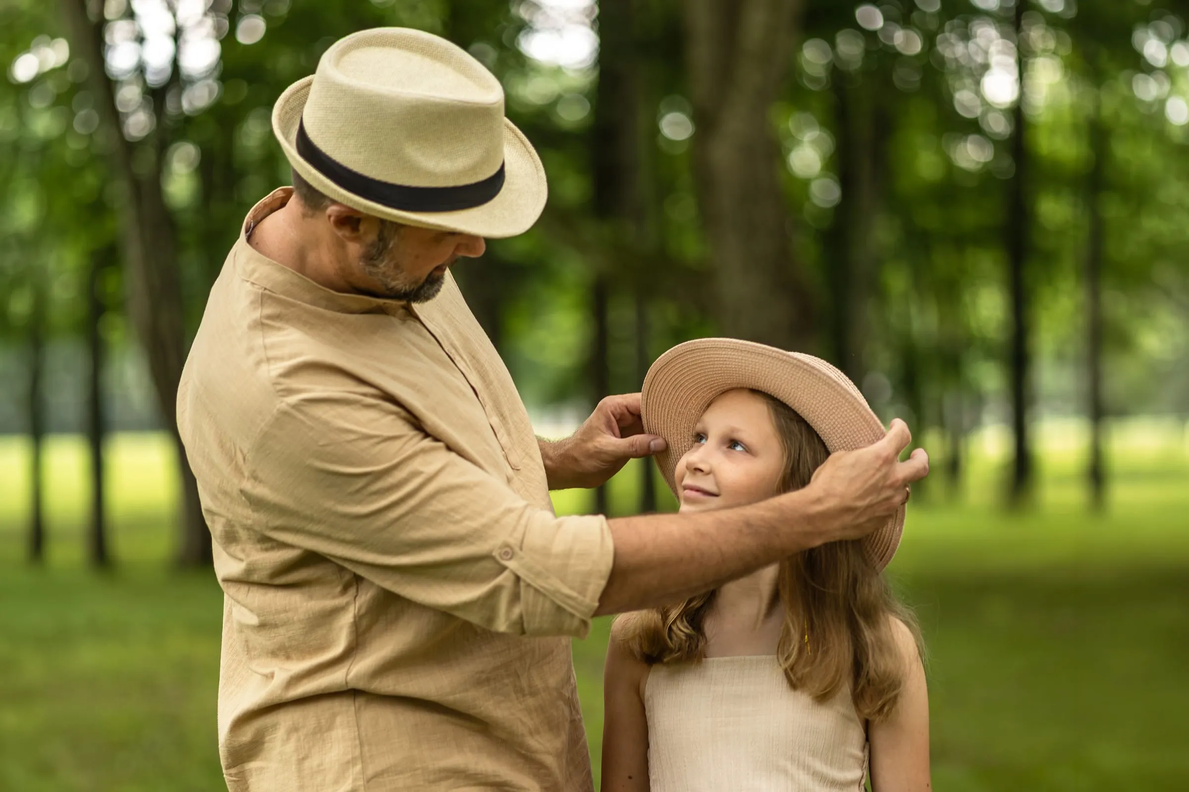 Dad adjusting his daughter’s straw hat