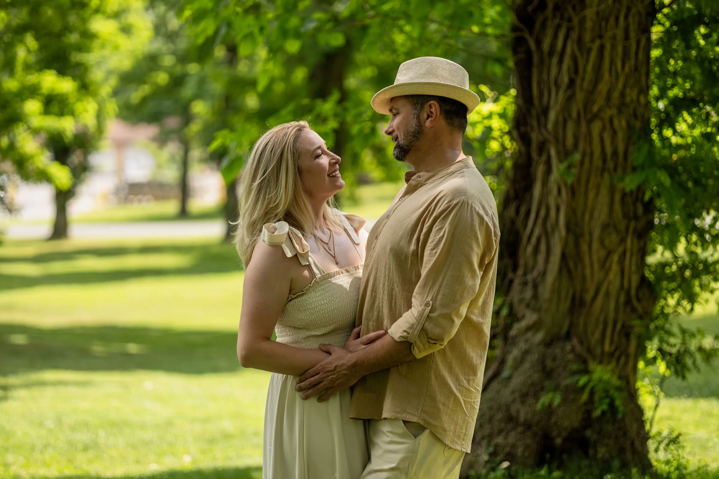 Husband and wife embracing beside a big tree