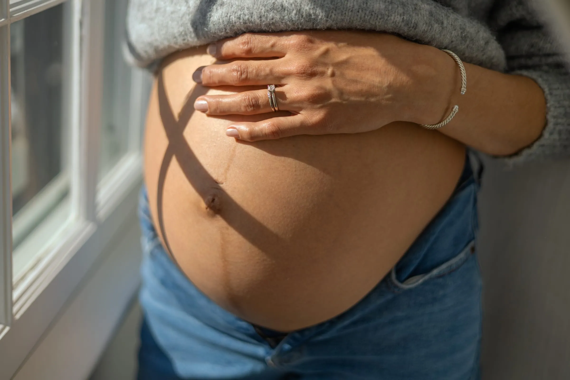 Pregnant belly in soft window light