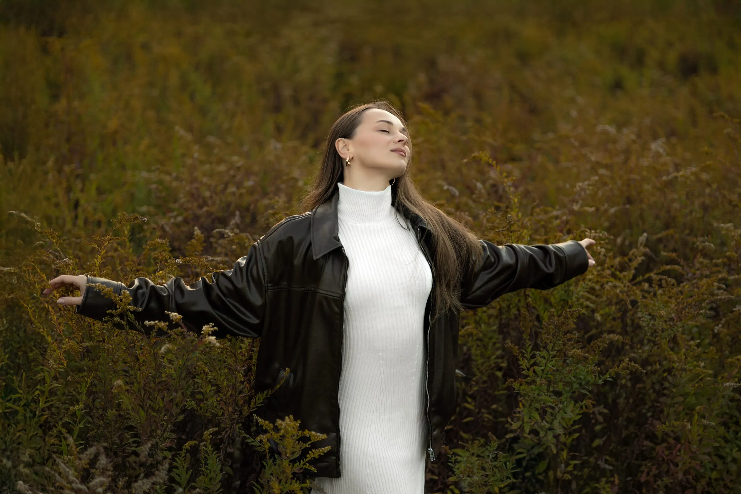 Woman with arms open in a golden field