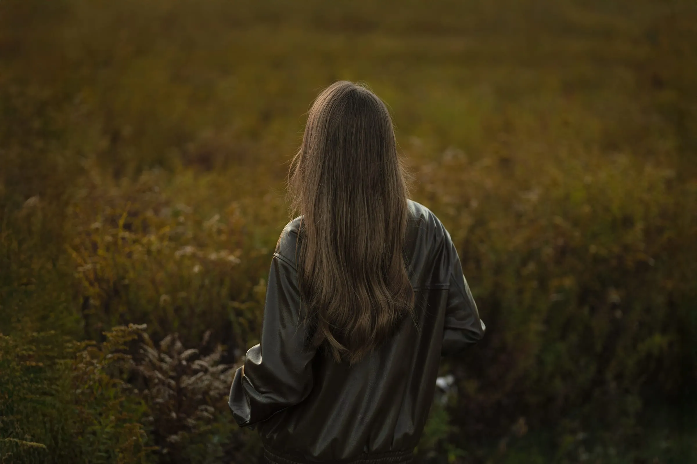 Woman walking away into an autumn field
